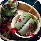 Two cones of pistachio ice cream on a plate, one in a glass