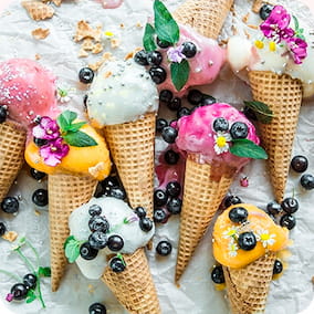A few waffle cones with different ice cream